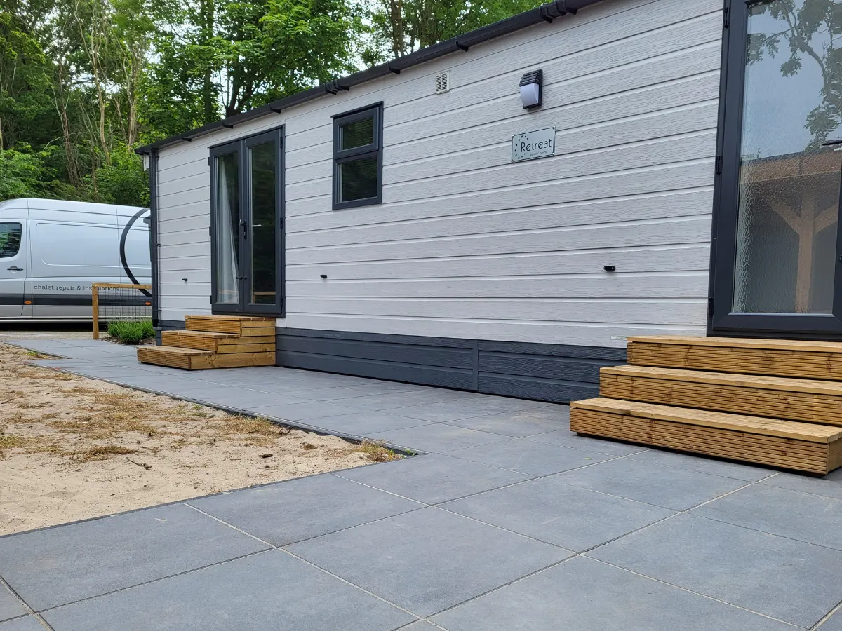 Nieuw geplaatst chalet met trappen en bestrating